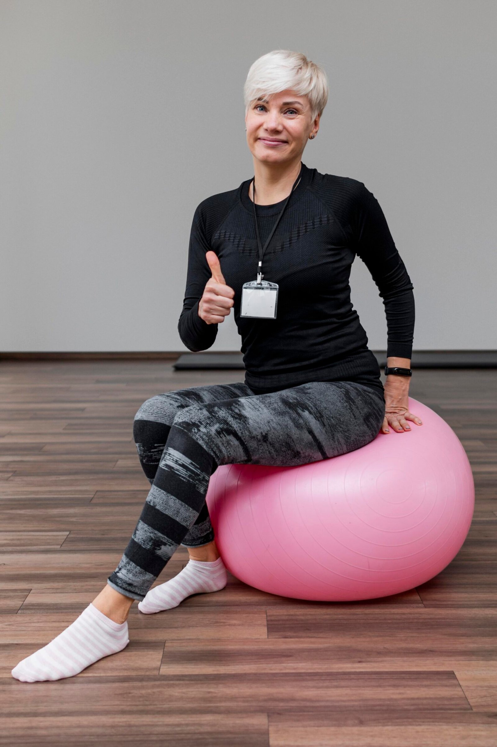 cute-personal-trainer-sitting-fitness-ball